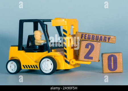 Februar 20th. 20. Tag des Monats, der Bau oder die Lager Kalender. Gelb Spielzeug Gabelstapler Last Holz Würfel mit Datum. Arbeit Planung und Zeitmanagement. Stockfoto