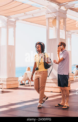 Schön, Provence/Frankreich - September 29, 2018: Junge afrikanische amerikanische Mädchen casual in Kopfhörer bei Sonnenbeschienenen boardwalk Stockfoto