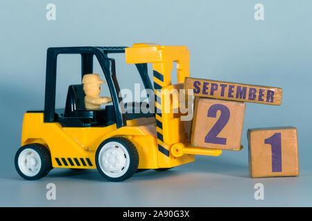 September 21.. 20. Tag des Monats, der Bau oder die Lager Kalender. Gelb Spielzeug Gabelstapler Last Holz Würfel mit Datum. Arbeit Planung und Zeitmanagement. Stockfoto