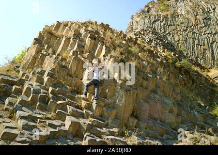 Man Klettern die Symphonie der Steine, Massive Basalt Spalte Formationen entlang der Garni Schlucht in Armenien Stockfoto