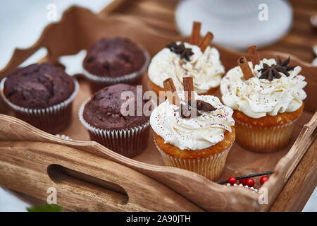 Muffins und Cupcakes mit Zimt auf einer hölzernen Fach close-up. Bild horizontal Stockfoto