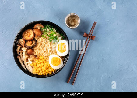 Ramen. Soba Nudeln mit gekochten Eiern, Shiitake-pilze, und Gemüse, Schuß von der Oberseite mit Stäbchen, Sake und ein Platz für Text Stockfoto