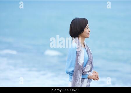 Ältere japanische Frau am Strand Stockfoto