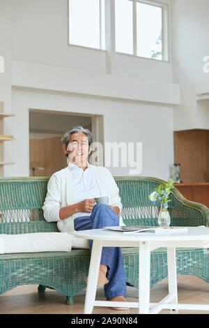 Senior japanischer Mann zu Hause Stockfoto