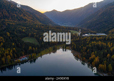 Luftaufnahme der See Lago di Anterselva und Herbst Wald während des Sonnenuntergangs. Italienische Alpen Stockfoto