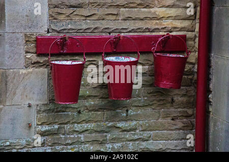 Feuer Eimer auf einer Wand an Dent Bahnhof, Cowgill, South Lakeland District von Cumbria, dem höchsten über dem Meeresspiegel in England bei 1150 Fuß Stockfoto