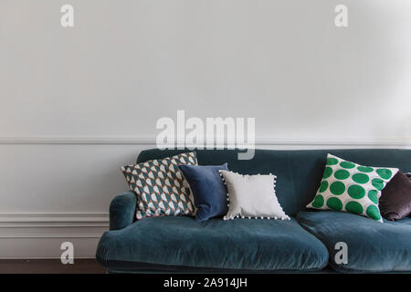 Komfortable Blaue Sofa in einem gegen eine einfache Wand. Interior Design Stockfoto