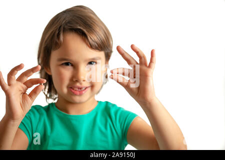 Mädchen mit Zahn in der Hand auf dem isolierten weißen Hintergrund. Glücklich und Stolz Stockfoto