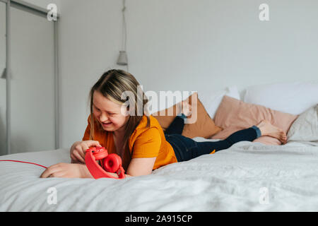 Smiling teenage Girl auf dem Bett Stockfoto