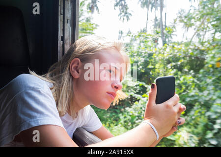 Mädchen nehmen Bild durch Zug Fenster Stockfoto