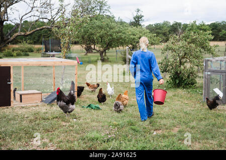 Frau Hühner füttern Stockfoto