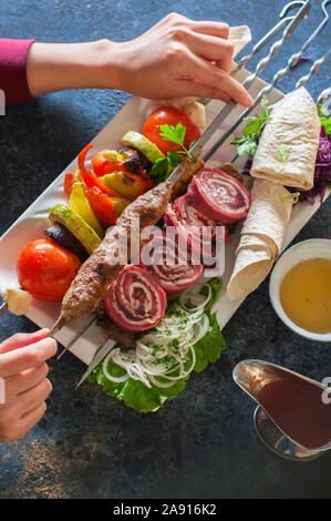 Sortierte Fleischspieße mit Gemüse und Gewürzen. Ansicht von oben. Stockfoto