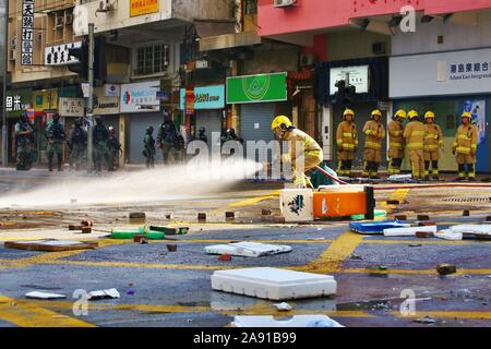 Hong Kong. 11 Nov, 2019. Auseinandersetzungen brechen in mehrere Bezirke zwischen Demonstranten und Polizei nach ein demonstrant von der Polizei erschossen wurde und ein Mann war auf Feuer durch Demonstranten während was schien ein Streit. Hier Feuerwehrleute sauber auf den Straßen. Credit: Gonzales Foto/Alamy leben Nachrichten Stockfoto
