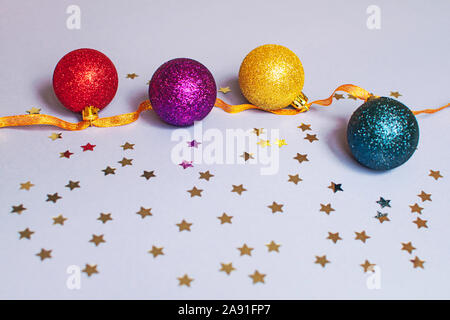Hell Funkelnde Weihnachten Kugeln auf lila Hintergrund. Weihnachten Kugeln auf ein Band mit Sternen Stockfoto