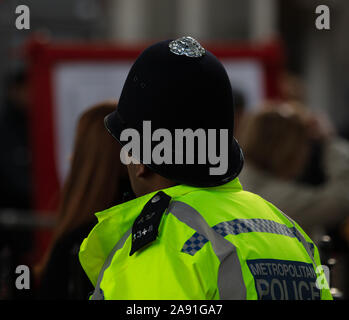 Polizisten, von hinten, von der Metropolitan Police Force in London, England, UK mit einem klassischen englischen Polizei Helm gesehen. Stockfoto