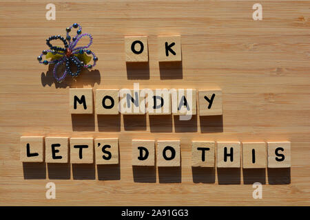 OK Montag, lassen Sie uns dies tun in 3D Holz- Buchstaben des Alphabets mit einem handgefertigten Glasperlen Blumen auf einem Bambus Holz Hintergrund Stockfoto