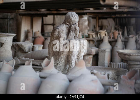 Pompei. Italien. Archäologische Stätte von Pompeji. Gips ein Opfer in der Ausbruch des Vesuv im Jahr 79 N.CHR. starb, durch Artefakte umgeben f Stockfoto