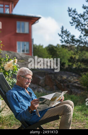 Senior woman lesen Zeitung Stockfoto