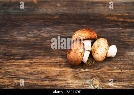 Stapel der Köstlichen champignon Pilze an Holz- Hintergrund. Stockfoto