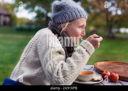 Frau essen im Garten Stockfoto