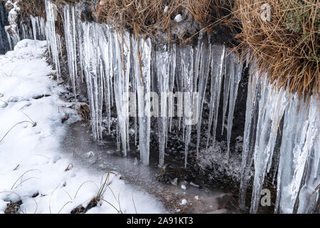 Eiszapfen am Rande eines Baches in den schottischen Highlands. Stockfoto