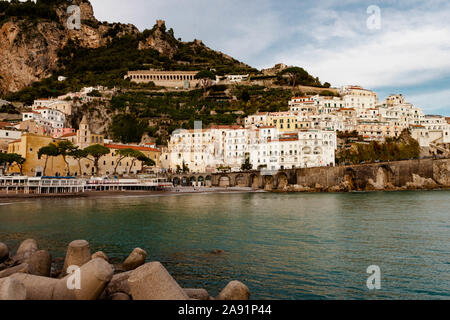 AMALFI, ITALIEN 7. NOVEMBER 2019: Amalfi am Tyrrhenischen Meer Landschaft sonnenuntergang stadt und Natur Panoramablick von der Pier. Häuser und Hotels, Kirche und c Stockfoto