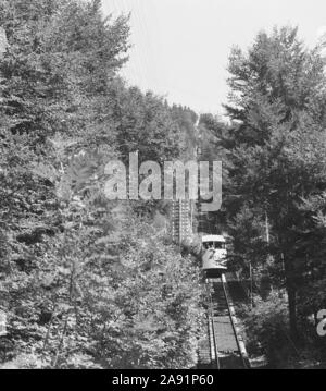 1950s, historisch, eine schweizer Bergbahn oder ein Wagen mit den Buchstaben SMS auf der Vorderseite, die von der Spitze des Mont-Soleil, einem Gipfel des Juras, in die Stadt Saint Imier, Bern, Schweiz, absteigt, eine Reise, die 1903 gegründet wurde. Eine Standseilbahn ist eine Seilbahnform an einem steilen Hang, an dem zwei Waggons an entgegengesetzten Enden einer Transportleitung befestigt sind. Stockfoto