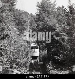 1950s, historisch, eine schweizer Bergbahn oder ein Wagen mit den Buchstaben SMS auf der Vorderseite, die von der Spitze des Mont-Soleil, einem Gipfel des Juras, in die Stadt Saint Imier, Bern, Schweiz, absteigt, eine Reise, die 1903 gegründet wurde. Eine Standseilbahn ist eine Form von Seilbahnen, bei denen zwei Wagen an gegenüberliegenden Enden eines Transportkabels befestigt sind. Stockfoto