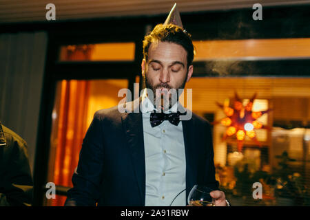 Mann rauchen Zigarre bei Party Stockfoto