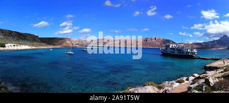 Panoramablick auf die Bucht zwischen Insel Gramvousa und Balos Bucht mit Booten in das Meer und ein Passagierschiff in Kreta, Griechenland verankert. Stockfoto