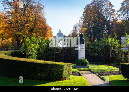 Brüssel, Belgien, 10. November 2019: Robert Schuman Statue in Brüssel, Belgien, mit dem Triumphbogen in Cinquantenaire Park im Hintergrund. Stockfoto