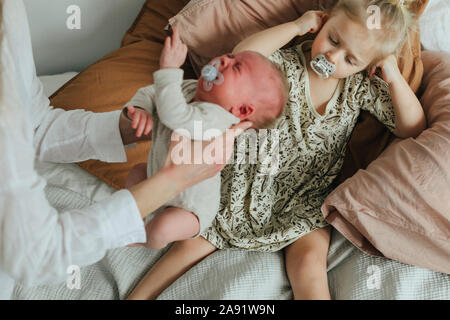 Mutter Holding Baby schreien, Mädchen auf Hintergrund Stockfoto