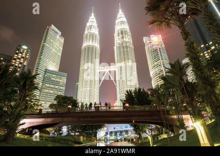 Atemberaubende Aussicht auf die Petronas Twin Tower leuchtet in der Dämmerung. Die Petronas Towers sind Zweibettzimmer Wolkenkratzer in Kuala Lumpur. Stockfoto