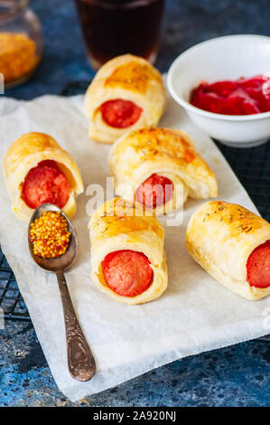 Schweine in einem planket - Blätterteig Brötchen mit Wurst auf einem Rack. Fast Food oder Snack Konzept. Stockfoto