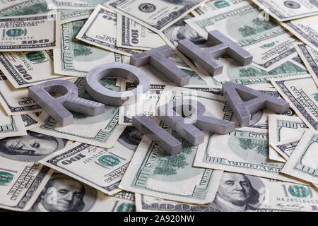 Die Worte ROTH IRA mit Aluminium Buchstaben auf den US-Dollar festgelegt Banknoten Hintergrund - mit selektiven Fokus und diagonale Komposition. Stockfoto