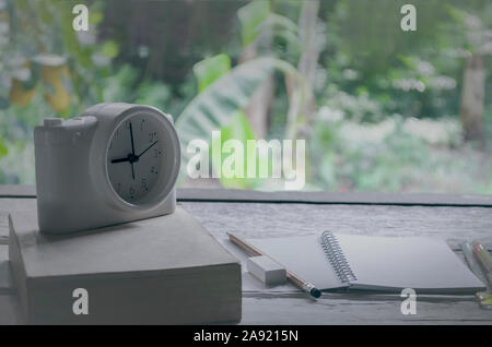 Jahrgang der Klasse Zimmer in Natur Hintergrund mit Hinweis Bücher, Bleistifte, Wecker auf alten Buch auf einem weißen Tisch Stockfoto