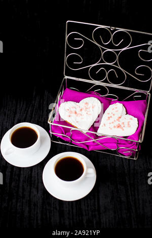 Valentinstag: zwei Tassen Kaffee und Gebäck in der Form von Herzen. Stockfoto