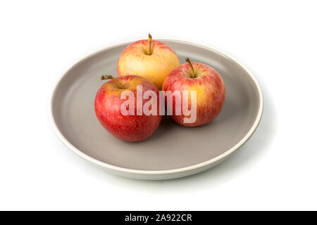 Platte von drei ganze Reife raw gelbe und rote Äpfel Stockfoto