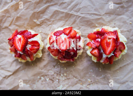 Sehr lecker Muffins mit frischen Erdbeeren liegen auf Kraftpapier. Stockfoto