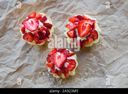 Sehr lecker Muffins mit frischen Erdbeeren liegen auf Kraftpapier. Stockfoto