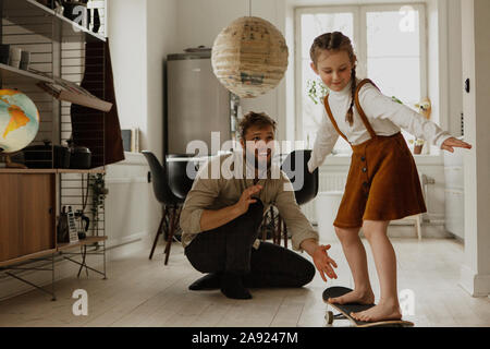 Mädchen auf Skateboard zu Hause Stockfoto