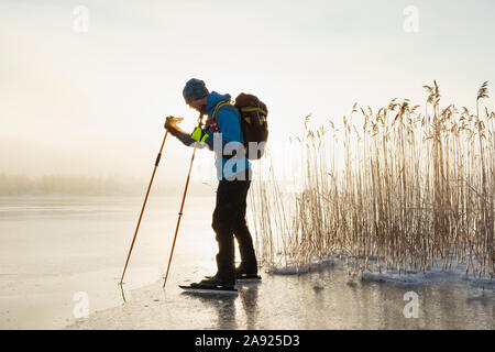 Mann, Schlittschuhlaufen auf dem zugefrorenen See Stockfoto