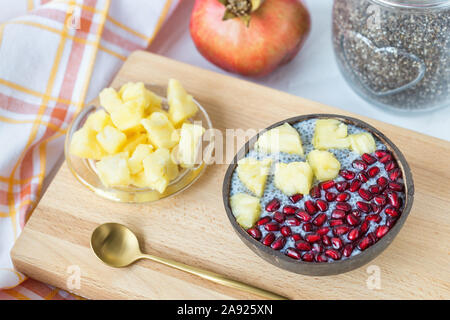 Chia Samen Pudding mit Mango und Granatapfel in eine Schüssel geben. Stockfoto