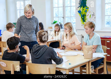 Schülerinnen und Schüler mit dem Lehrer im Klassenzimmer Stockfoto