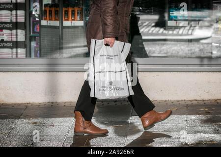 Ein Mann, der einen House of Fraser Kunststoff Tragetasche 100 % aus recyceltem Kunststoff wiederverwendbar Supermarkt Taschen für das Leben Stockfoto