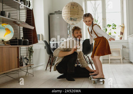 Mädchen auf Skateboard zu Hause Stockfoto