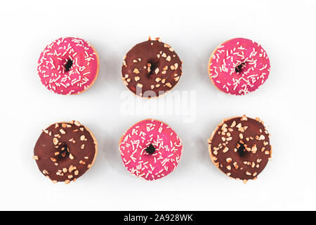 Sechs Donuts mit leuchtend rosa und brauner Schokolade glasieren und Zucker Streusel auf weißem Hintergrund Stockfoto