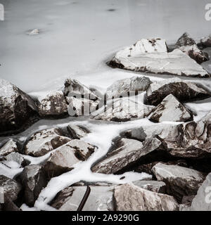 Eis und Marmor. Ein gefrorenes Wasser in einem alten, verlassenen Steinbruch kreative eine abstrakte grauer Hintergrund Textur. Stockfoto