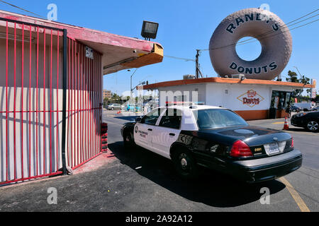 Polizei Auto vor der legendären Donut snack' Randy's Donut' im Stadtteil Inglewood, Los Angeles, Kalifornien, USA Stockfoto