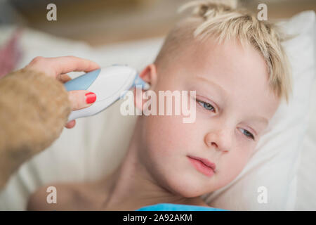 Junge mit seiner Temperatur genommen Stockfoto